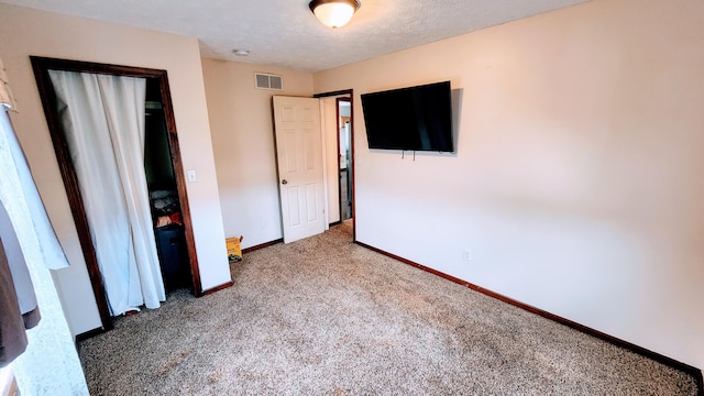 unfurnished bedroom with carpet floors and a textured ceiling