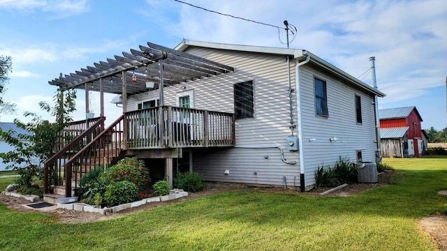 rear view of house with a lawn, a pergola, a wooden deck, and central AC