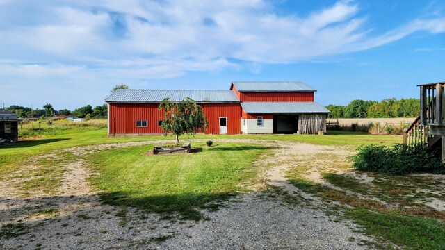 12448 Jefferson Rd, Morley, MI 49336 - rear view of property featuring a lawn, metal roof, driveway, an outdoor structure, and an outbuilding