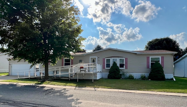 manufactured / mobile home featuring a deck and a front lawn