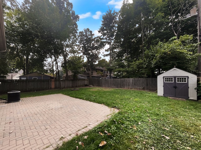 view of yard with a storage unit, a patio area, and central air condition unit