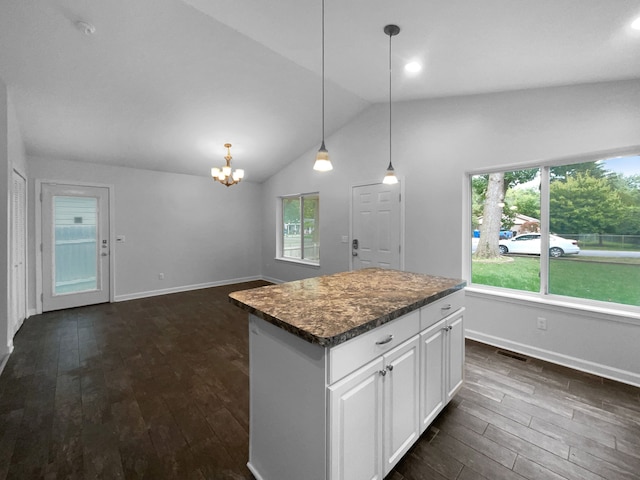 kitchen with a wealth of natural light, white cabinetry, a kitchen island, and vaulted ceiling