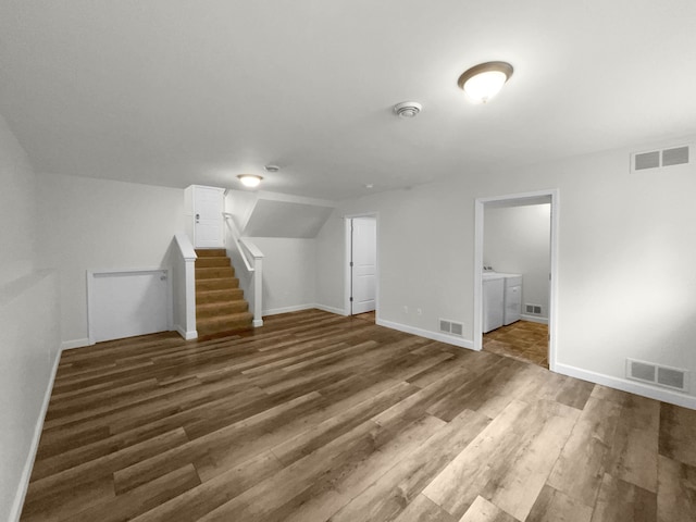 unfurnished living room featuring washing machine and dryer and dark hardwood / wood-style floors