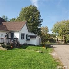 view of side of home featuring a lawn and a garage