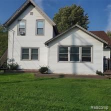 rear view of property featuring a lawn