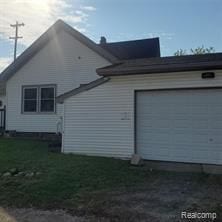 view of side of home with a lawn and a garage