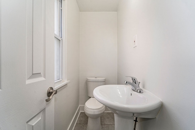 bathroom with toilet, tile patterned floors, and sink