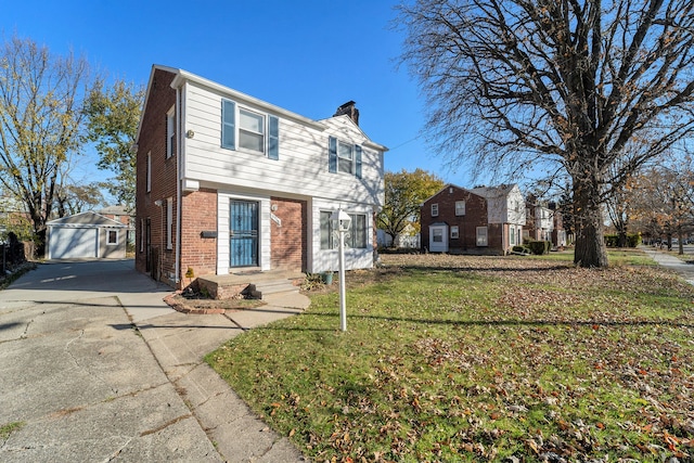 view of front of house with an outbuilding, a front yard, and a garage