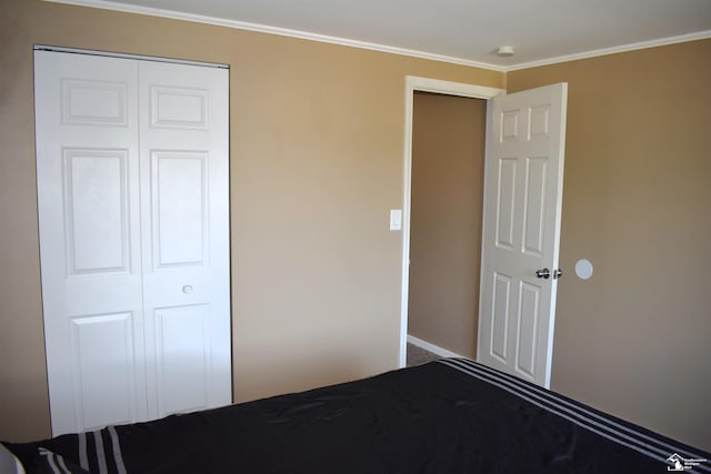 unfurnished bedroom featuring crown molding and a closet