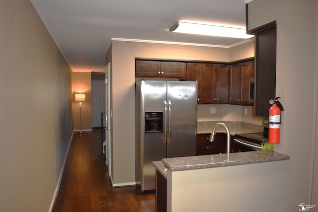 kitchen with dark brown cabinetry, light stone counters, dark hardwood / wood-style floors, kitchen peninsula, and appliances with stainless steel finishes