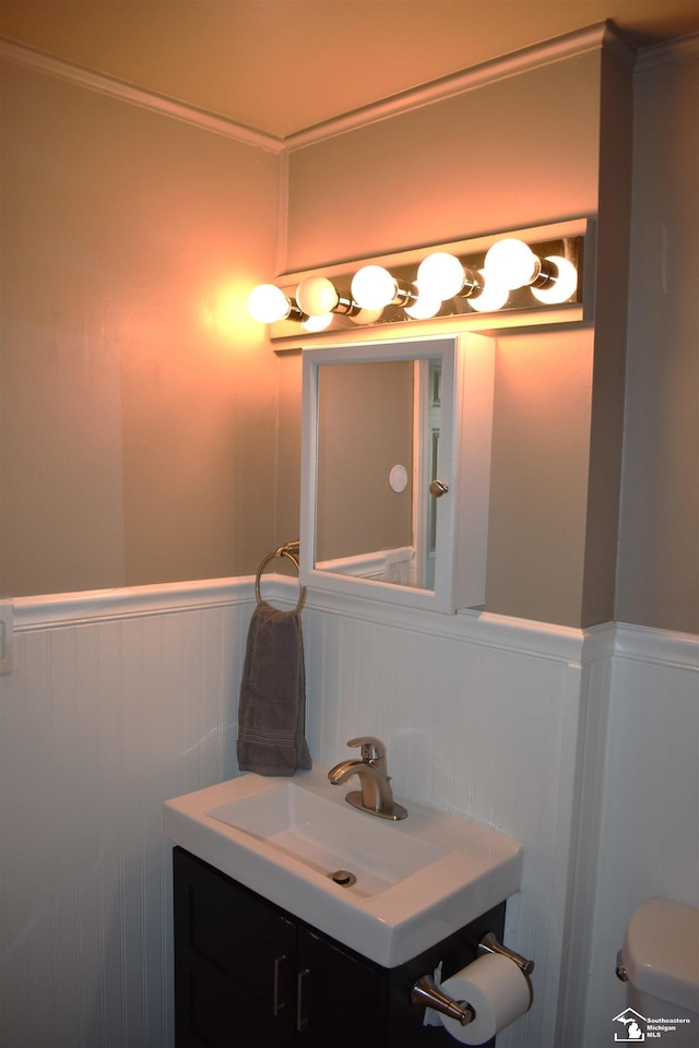 bathroom with vanity, toilet, and ornamental molding