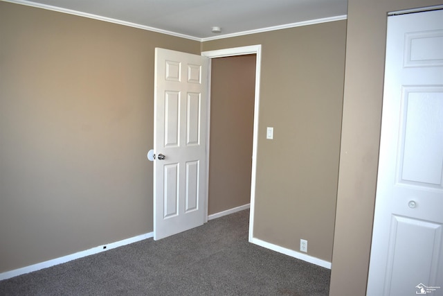 unfurnished bedroom featuring dark colored carpet and ornamental molding