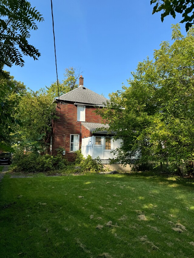 2986 Cadillac Blvd, Detroit, MI 48214 - back of house with a chimney, a yard, and brick siding