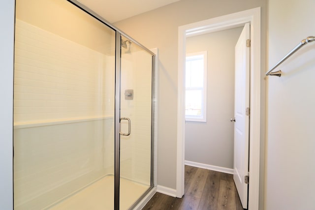 bathroom with an enclosed shower and hardwood / wood-style floors