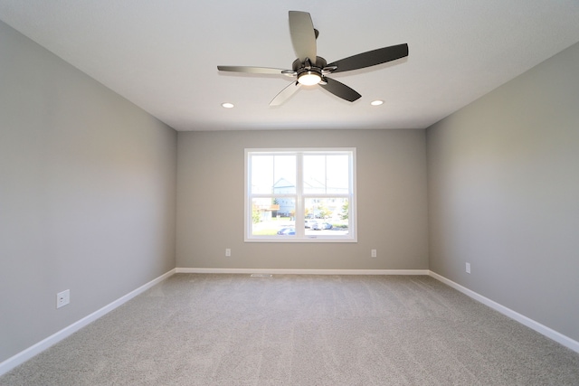 carpeted spare room with ceiling fan