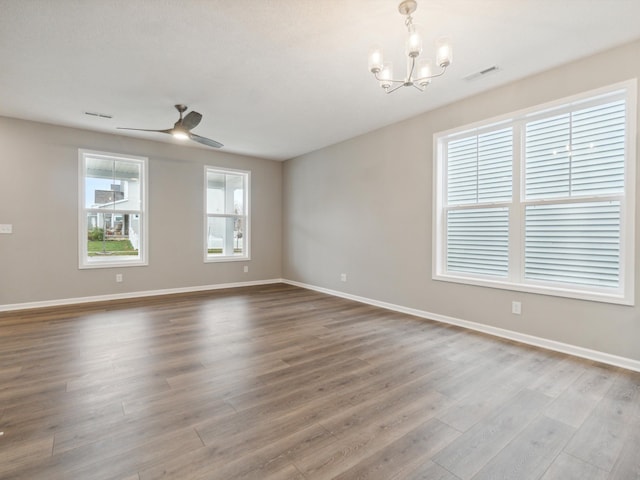 unfurnished room featuring ceiling fan with notable chandelier and hardwood / wood-style floors