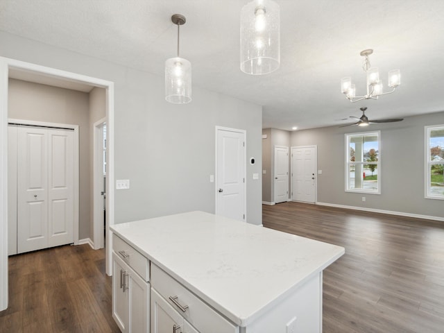 kitchen featuring white cabinetry, a kitchen island, pendant lighting, and dark hardwood / wood-style flooring