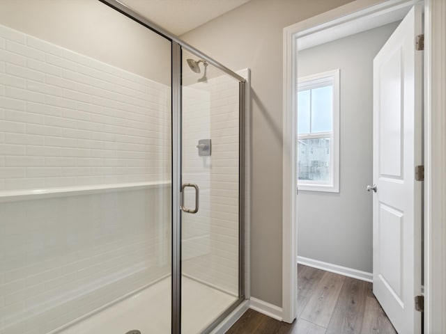 bathroom featuring wood-type flooring and walk in shower