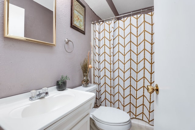 bathroom featuring a shower with shower curtain, a textured ceiling, vanity, and toilet