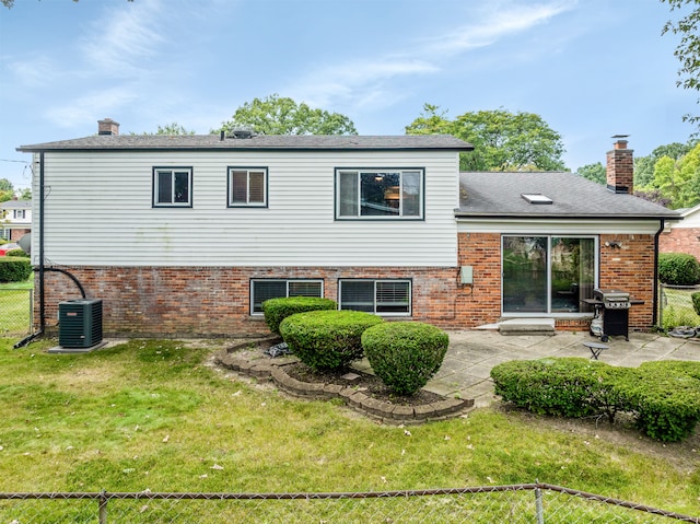 back of house with central AC unit, a patio area, and a lawn