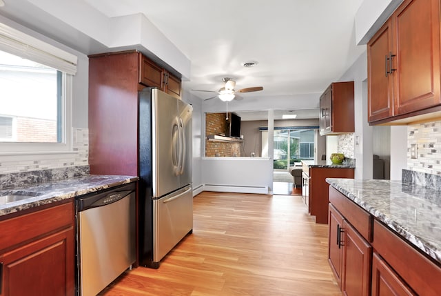 kitchen featuring decorative backsplash, light wood-type flooring, appliances with stainless steel finishes, and a baseboard heating unit