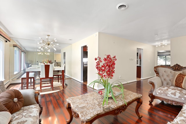 living room featuring dark hardwood / wood-style floors, a healthy amount of sunlight, and an inviting chandelier