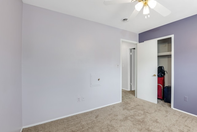 unfurnished bedroom with ceiling fan, a closet, and light carpet