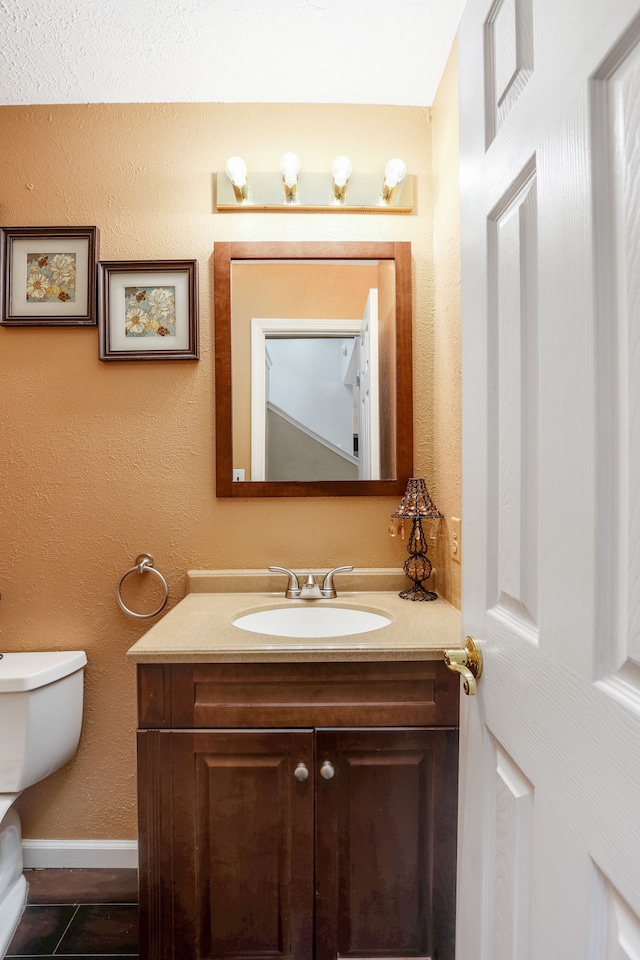 bathroom with tile patterned flooring, vanity, and toilet