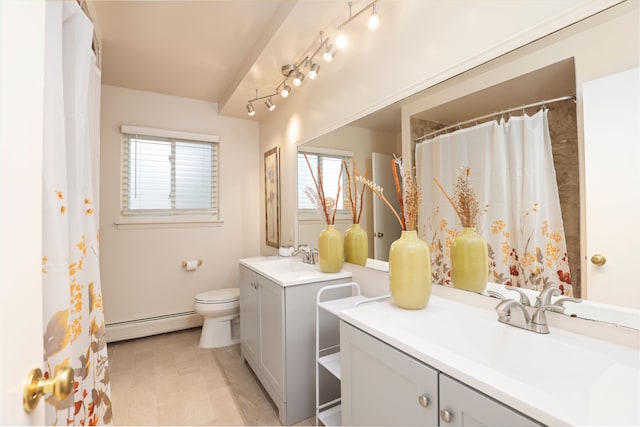 bathroom with baseboard heating, a wealth of natural light, vanity, and toilet