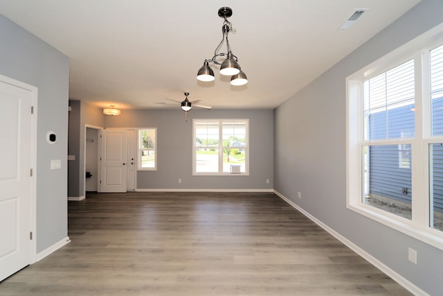 unfurnished room featuring ceiling fan with notable chandelier and wood-type flooring