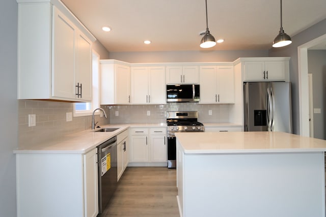 kitchen featuring white cabinetry, sink, pendant lighting, and appliances with stainless steel finishes