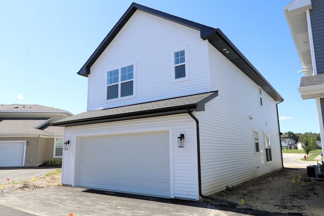 exterior space featuring a garage and cooling unit