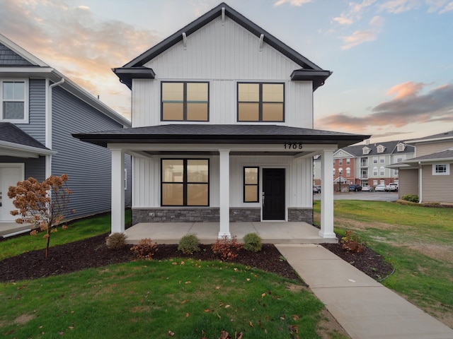 modern inspired farmhouse featuring a porch and a lawn