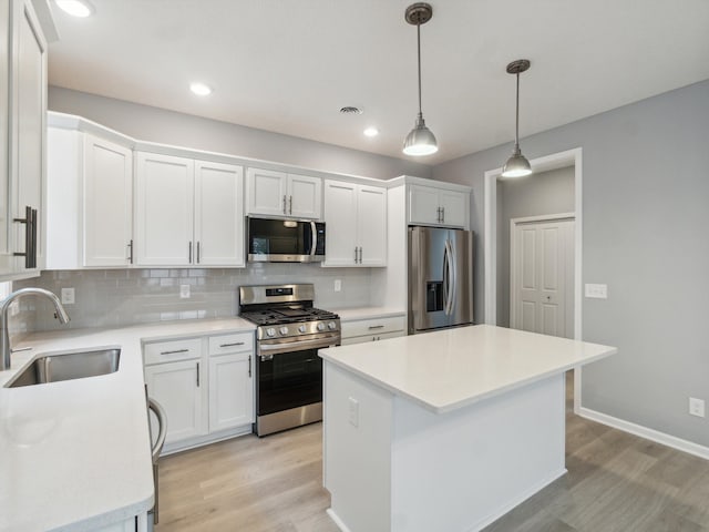 kitchen with a center island, sink, white cabinets, and stainless steel appliances