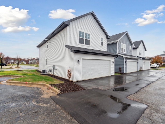 view of home's exterior with cooling unit and a garage