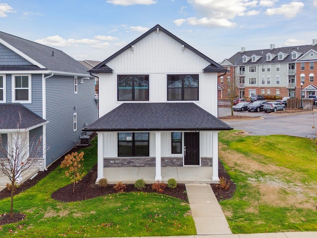 view of front of house featuring a front yard and central AC