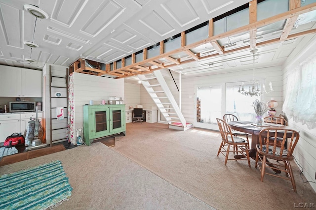 interior space with carpet flooring, wooden walls, and a notable chandelier