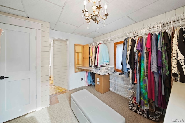 spacious closet featuring a drop ceiling and a notable chandelier