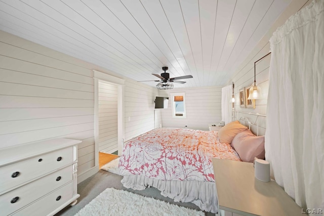 bedroom with ceiling fan, wooden ceiling, and wooden walls