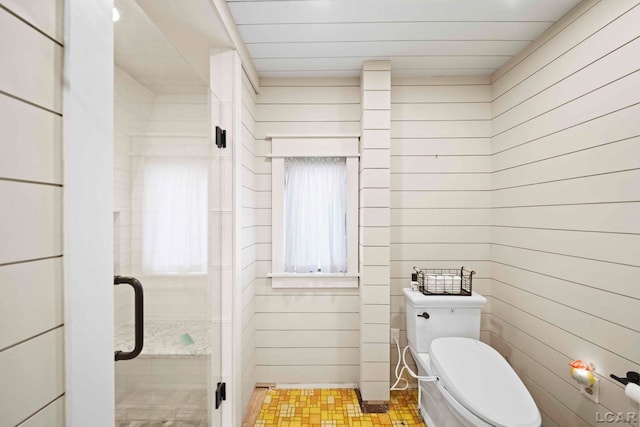 bathroom with walk in shower, wood walls, and toilet