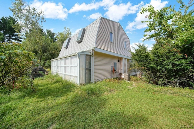 view of side of home featuring central air condition unit and a sunroom