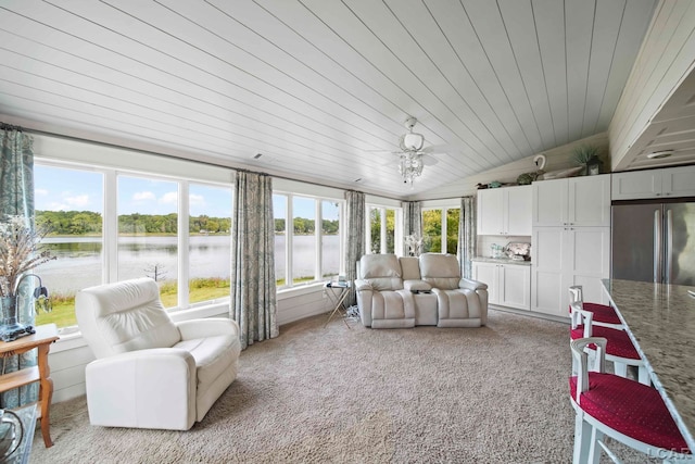 sunroom / solarium with ceiling fan, a water view, a healthy amount of sunlight, and vaulted ceiling