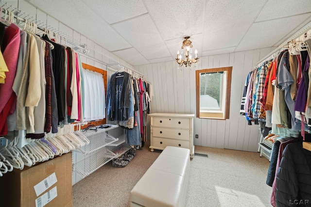 walk in closet featuring a notable chandelier and a drop ceiling