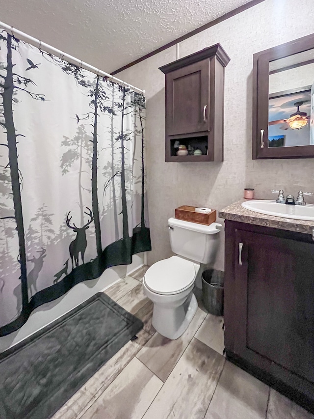 bathroom featuring vanity, a textured ceiling, toilet, and crown molding