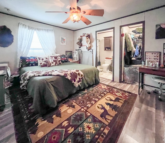 bedroom with ceiling fan, a spacious closet, ensuite bathroom, wood-type flooring, and a closet