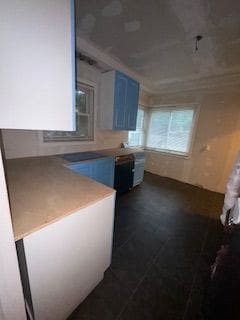 14257 Warwick St, Detroit, MI 48223 - kitchen with blue cabinetry and dark tile patterned flooring