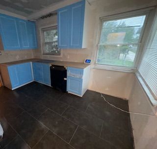 14257 Warwick St, Detroit, MI 48223 - kitchen with blue cabinetry, dark tile patterned floors, and built in study area