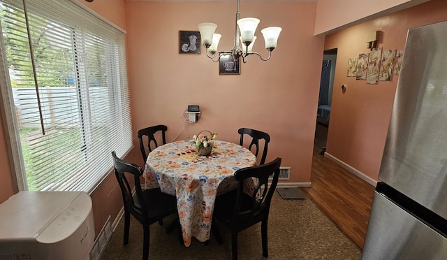 dining area featuring wood-type flooring and a notable chandelier