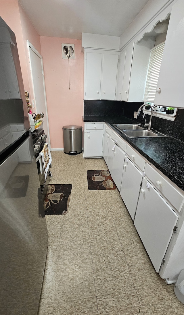 kitchen with white dishwasher, white cabinetry, and sink