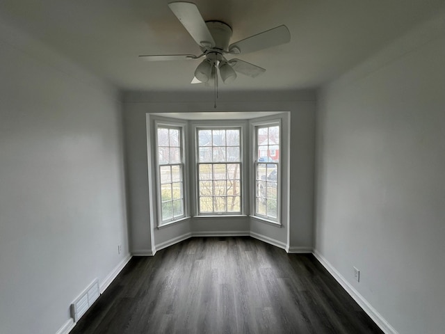 unfurnished room with dark hardwood / wood-style flooring and ceiling fan